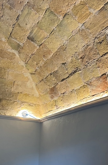 Restored brick ceiling in an Italian home with custom molding and LED lighting installed along the edges to highlight the historic architecture