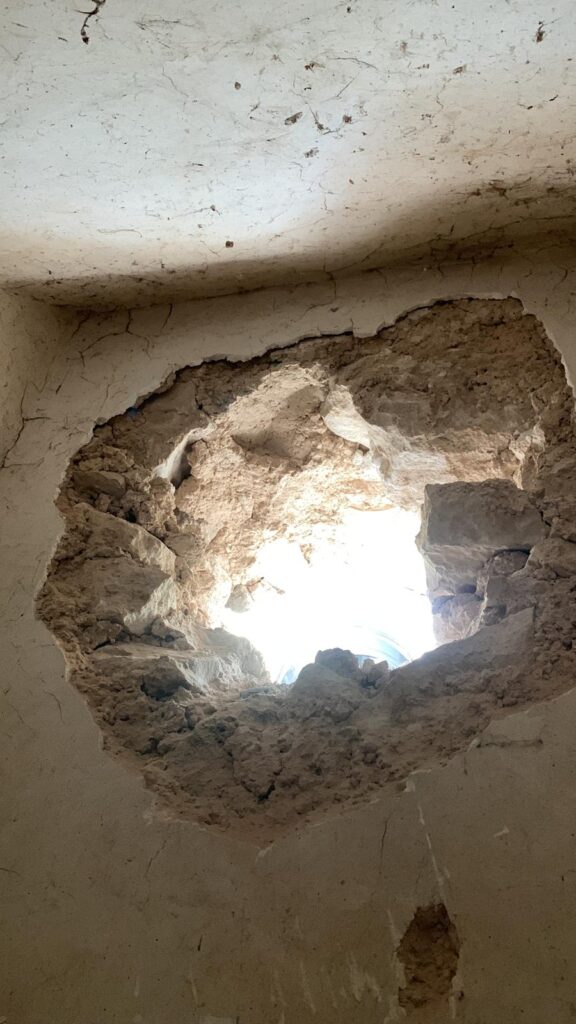 Opening in a stone wall for a wood oven stack installation in an Italian kitchen.