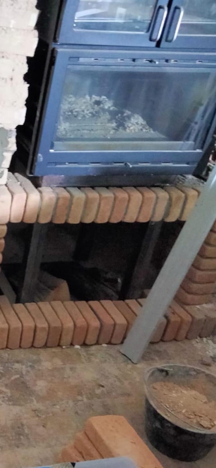 Brickwork taking shape beneath our wood-burning bread oven during the installation.