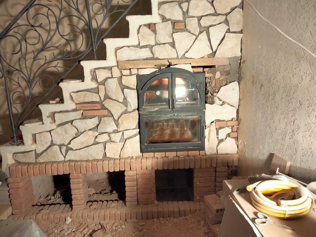 Limestone wall work surrounding the wood-burning bread oven during our Italian kitchen restoration.