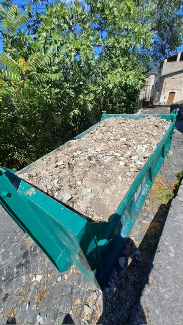 Rubble from the demolished bathroom piled inside a construction garbage skip
