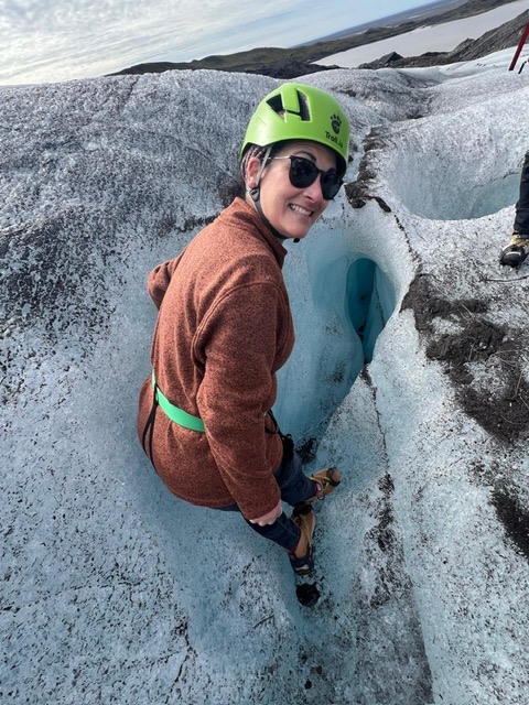 Inspecting a moulin hole in the ice during our Iceland glacier tour.