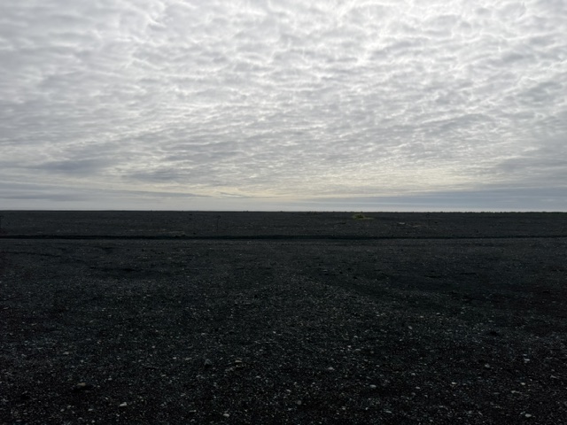 Empty black sand landscape beneath a cloudy sky during our Iceland Ring Road campervan trip.