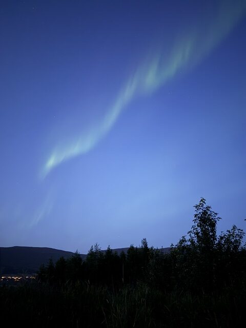 Green aurora borealis glowing across the night sky during our Iceland Ring Road trip.