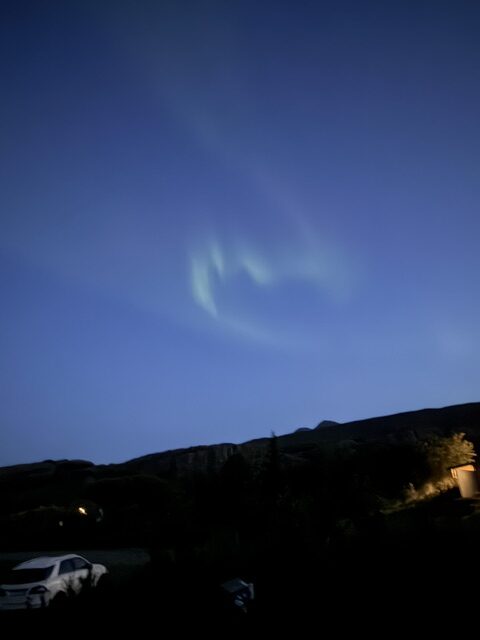 Bright green Northern Lights stretching across the dark Icelandic sky.