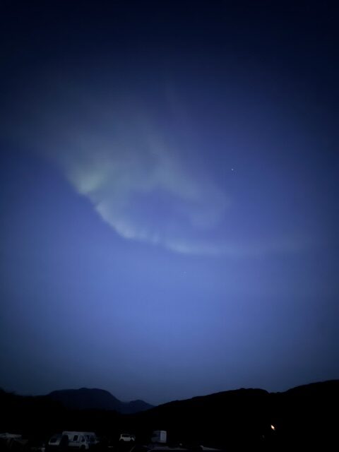 Green bands of Northern Lights sweeping across the night sky in Iceland.