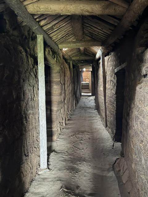 Dark timber passage inside the reconstructed Viking Village near Vestrahorn, Iceland.