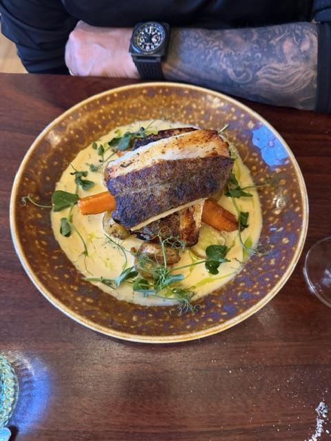 Fresh fish served with vegetables and creamy sauce during dinner in Höfn, Iceland.