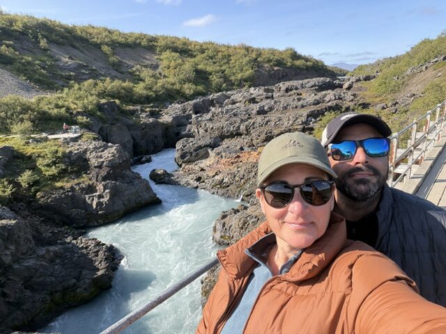 Waterfall feeding a winding river through the Icelandic landscape.
